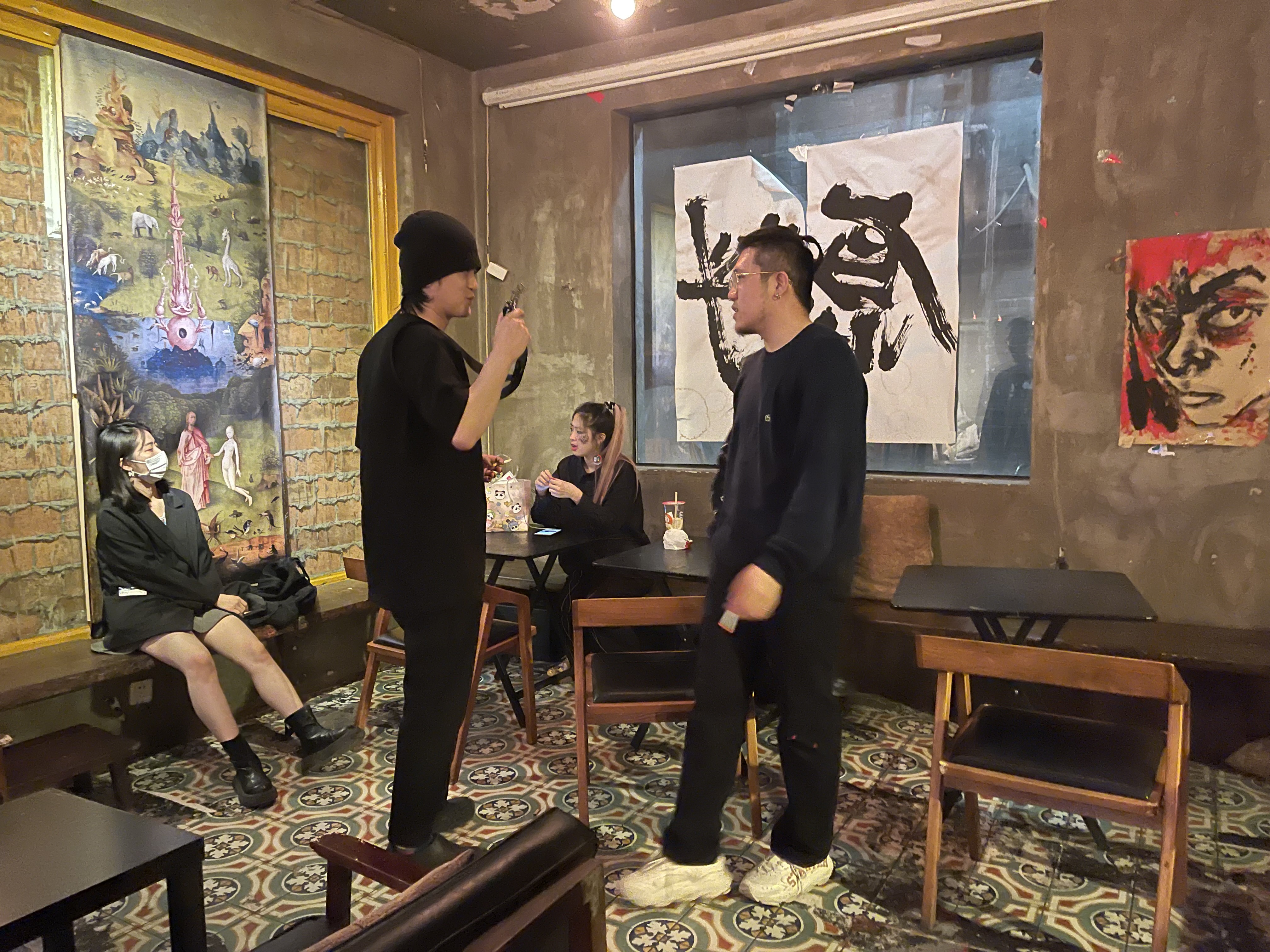 两人站在室内交谈,其他人坐在周围。来自《玻璃动物园》工作档案。