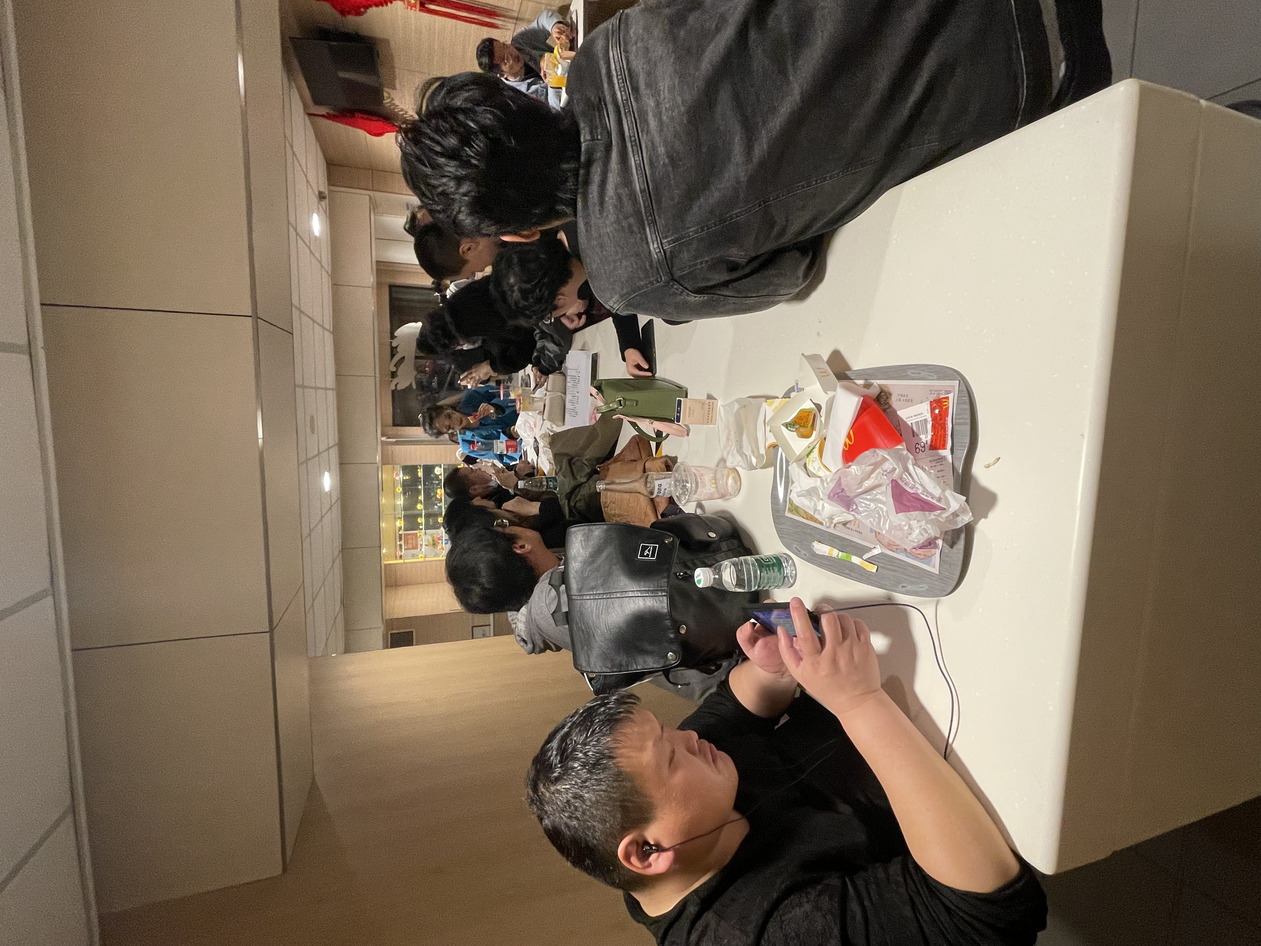参与者围坐长桌,桌面放有纸页与随身物品。来自《玻璃动物园》工作档案。